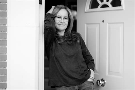 Black And White Portrait Of A Mature White Woman At The Door Of Her