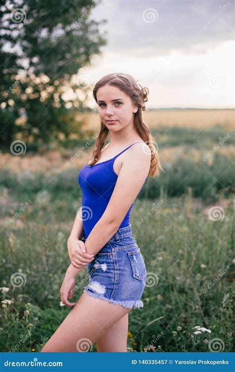 Beautiful Girl In Short Shorts And In A Blue T Shirt On The Field Stock