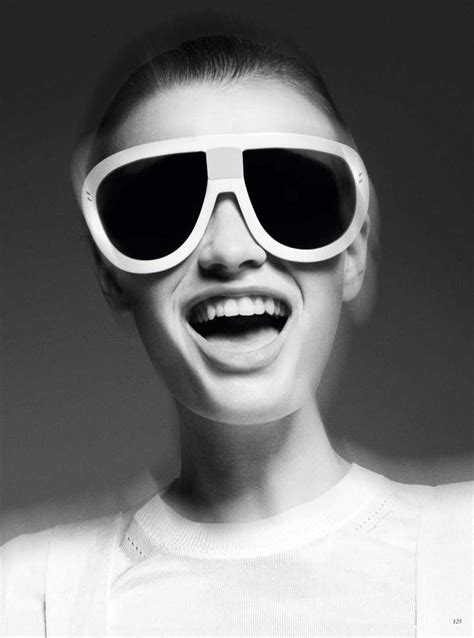 A Woman Wearing Sunglasses And Smiling For The Camera With Her Mouth