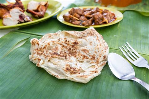 Roti Canai Or Paratha Served On Banana Leaf With Mutton Curry And