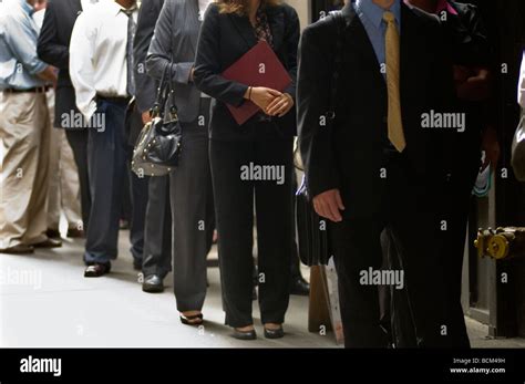 Job seekers line up waiting for the doors to open at a job fair in