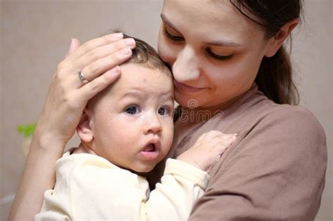 Pretty Young Mother Holding Her Newborn Baby Boy Close Up Stock Photo