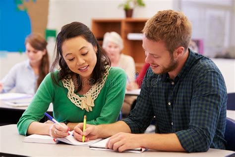 Teacher And Student Work Together At Adult Education Class Stock Photo