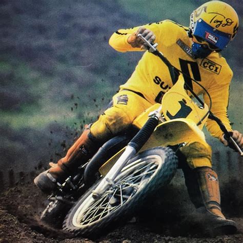 A Man Riding On The Back Of A Dirt Bike Down A Muddy Hill In Yellow