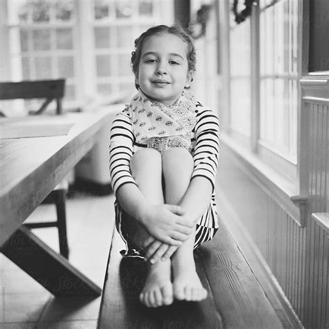 Cute Babe Girl Holding Her Legs Sitting On A Bench By Stocksy Contributor Jakob Lagerstedt