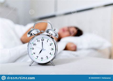 Wake Up Of An Asleep Girl Stopping Alarm Clock On The Bed In The
