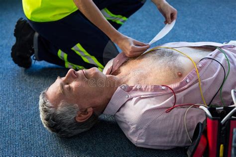 Paramedic Using An External Defibrillator During Cardiopulmonary Resuscitation Stock Image