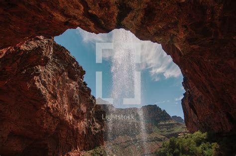 Misting Waterfall Over A Red Rock Cliff — Photo — Lightstock
