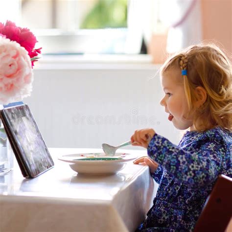 Niña Pequeña Adorable Comiendo Cereales Saludables Con Leche Para El Desayuno Y Viendo