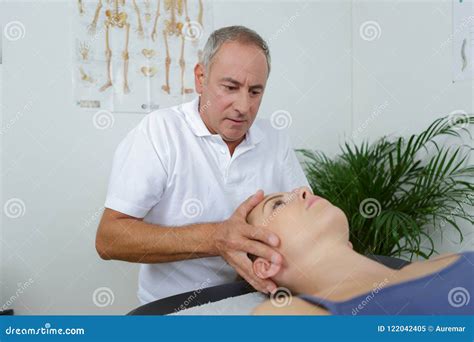 Massage Physiotherapist Doing Hand Massage Of A Female Athlete In Medical Office Background
