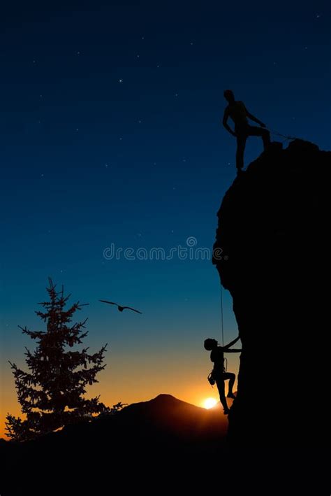 Silhouettes Of Two People Climbing On Mountain And Helping Stock Image