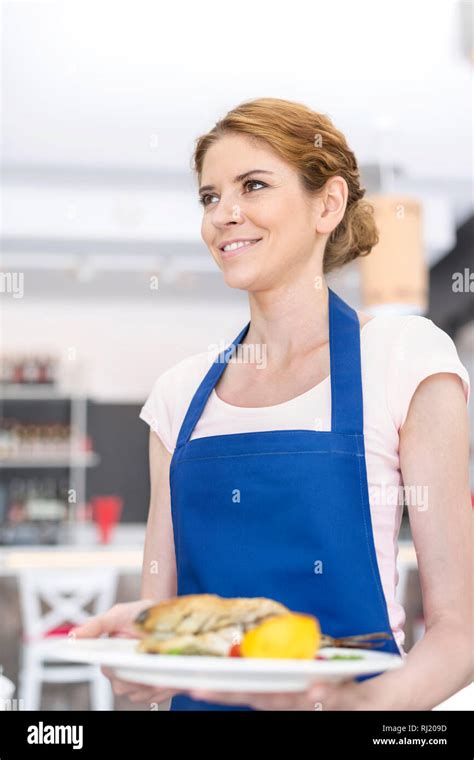 Smiling Young Waitress Serving Meal At Restaurant Stock Photo Alamy