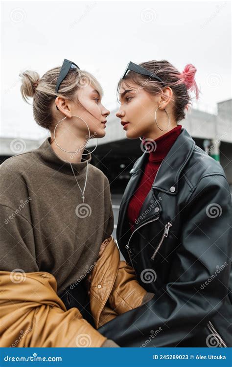 Two Beautiful Young Lesbian Girls In Fashionable Clothes With Leather Jacket On The Street Stock