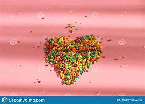 caramelos multicolores sobre fondo rosa concepto alimentario imagen de archivo imagen de