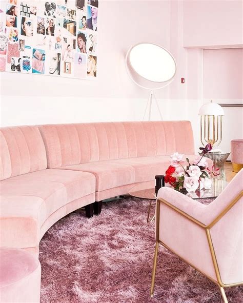 a living room with pink furniture and pictures on the wall