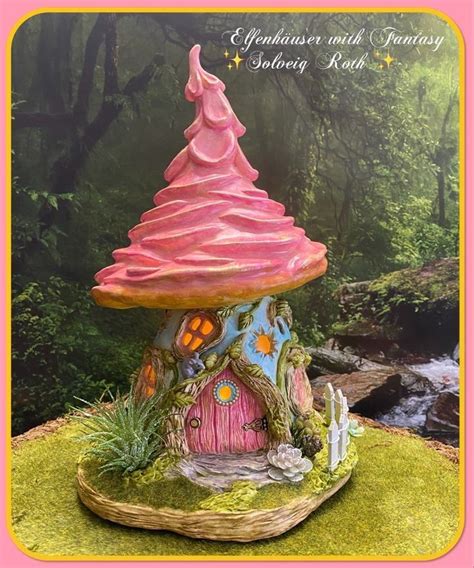 A Pink Fairy House Sitting On Top Of A Lush Green Field