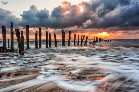 Time Lapse Photography Of Flowing Sea Water Nearby Standing Poles Hd