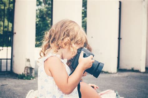 Little Girl Holding A Camera And Taking Pictures Stock Photo Image