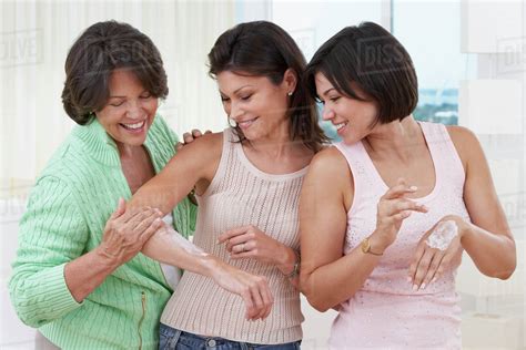 Mother And Sisters Applying Lotion To Skin Stock Photo Dissolve
