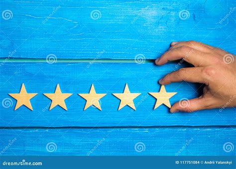A Woman`s Hand Puts The Fifth Star Quality Status Is Five Stars Stock