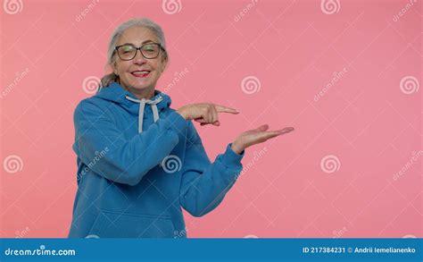 Mature Grandmother Showing Thumbs Up And Pointing Empty Place Advertising Area For Commercial
