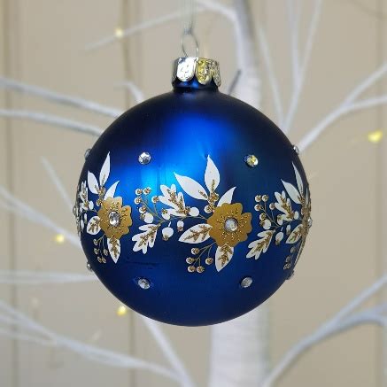 Time to dust off those wreathes and garlands. Matt blue glass Christmas bauble with white gold garland ...