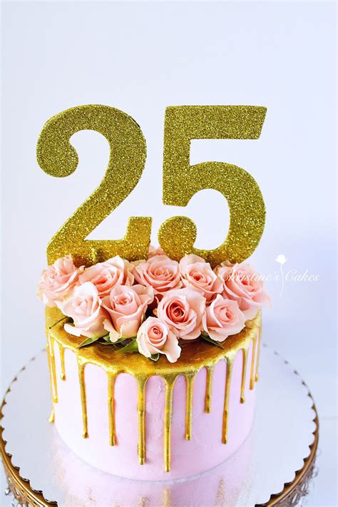 A Pink And Gold Birthday Cake With Flowers On The Top Is Decorated With