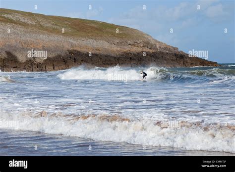 A surfer rides the waves on Broadhaven south beach Stock Photo - Alamy