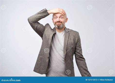 Closeup Portrait Of A Man Holding His Hand On Head Staring Thoughtfully At Camera Stock Image