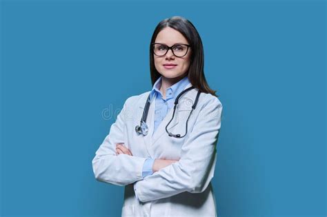 Portrait Of Confident Female Doctor Looking At Camera On Blue