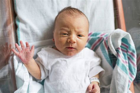 Overhead Newborn Baby Boy In Hospital Bassinet Making Eye Contact