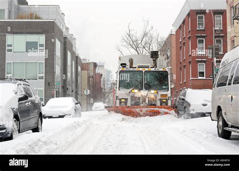 A Garbage Truck Fitted With A Snow Plow Clears Snow During Winter Storm