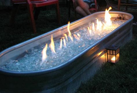 The enclosure is the body of a fire pit. Hillbilly fire pit. Horse trough with natural gas fire ...
