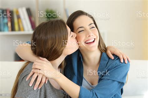 mädchen küssen ihre freundin auf der couch zu hause stockfoto und mehr bilder von behaglich istock