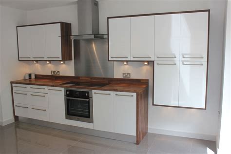 The ikea kitchen looks more like light grey quartz worktops. white gloss kitchen with wood wrap around. | Kitchen ...