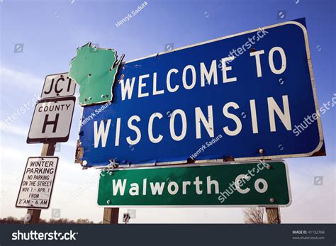 A Welcome To Wisconsin Street Sign With Other Road Signs Below It In