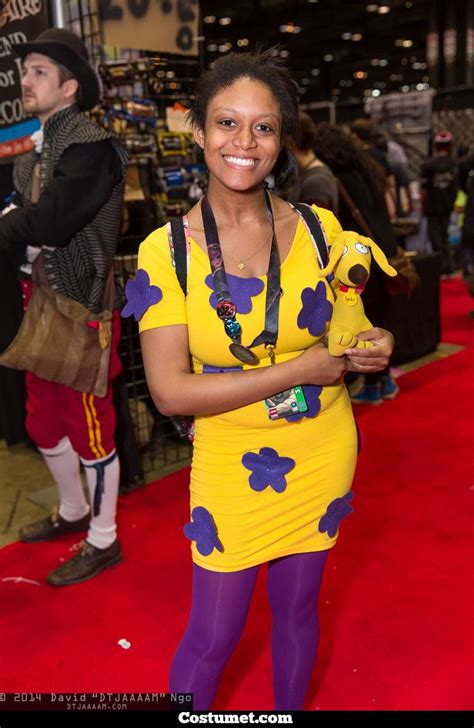 A Woman In A Yellow Dress And Purple Tights Is Holding A Stuffed Animal