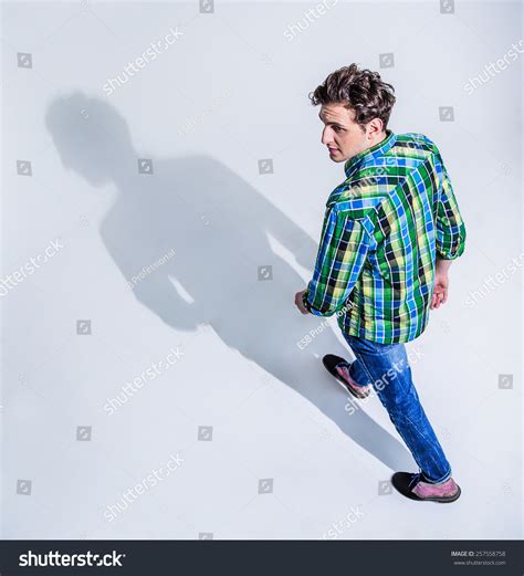 Top View Portrait Of A Young Man In Colourful Wear Walking Over Gray