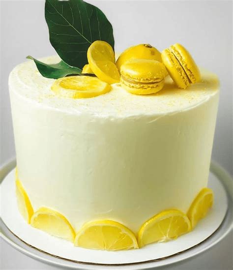A White Cake With Lemons And Macaroons On Top