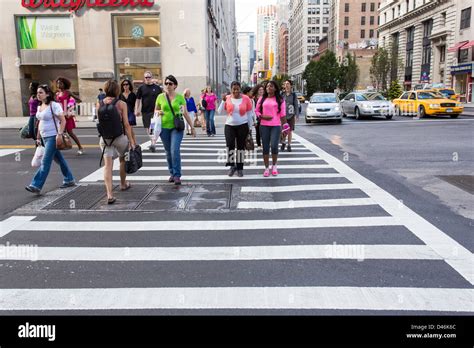 People Crossing A Street Using A Crosswalk In New York City Stock Photo