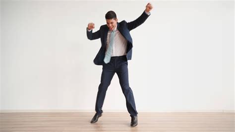 Funny business man dancing for joy and success on a white background