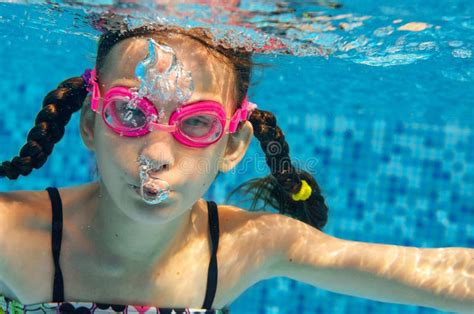Child Swims In Pool Underwater Funny Happy Girl In Goggles Has Fun