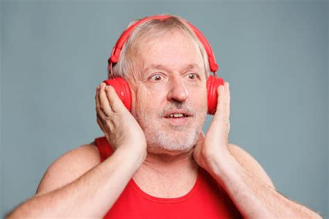 A Senior Elderly Man Is Listening To Music Through His Headphones