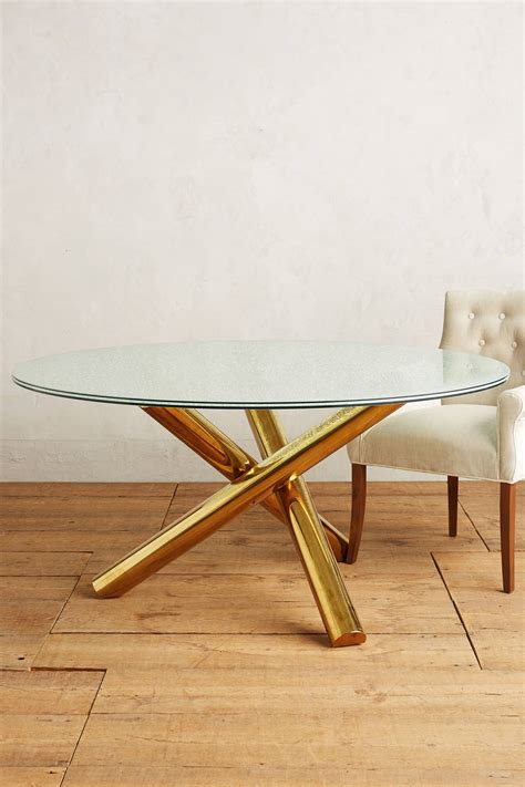 Three intertwined stainless steel posts are fused together, forming the beautiful look of the this tripod dining table. Crackled Glass Dining Table | Anthropologie