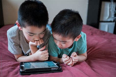 Asian Kids Playing Game On The Tablet Computer By Stocksy Contributor