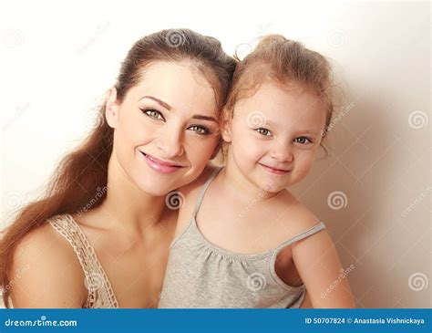 Madre Sonriente Hermosa Y Pequeña Hija Feliz Que Abrazan Foto De