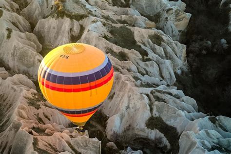 Premium Photo Hot Air Balloon Flying Over Rock Landscape At
