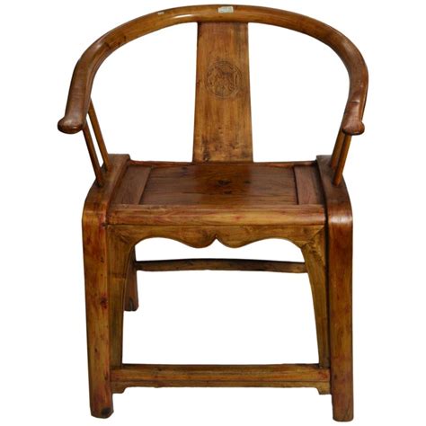 Wooden child's chair feature wooden front feet carved resemble cowboy boots and relief carving of a bucking bronco on chair back. 19th Century Chinese Hand-Carved Wooden Chair with Horseshoe Back and Stretcher For Sale at 1stDibs
