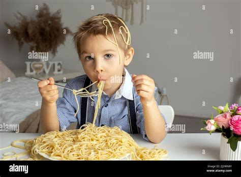 Cute Preschool Child Blond Boy Eating Spaghetti At Home Making A