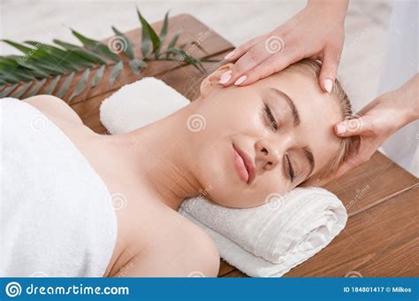Female Hands Do Rejuvenating Face Massage For Woman On Table With Palm